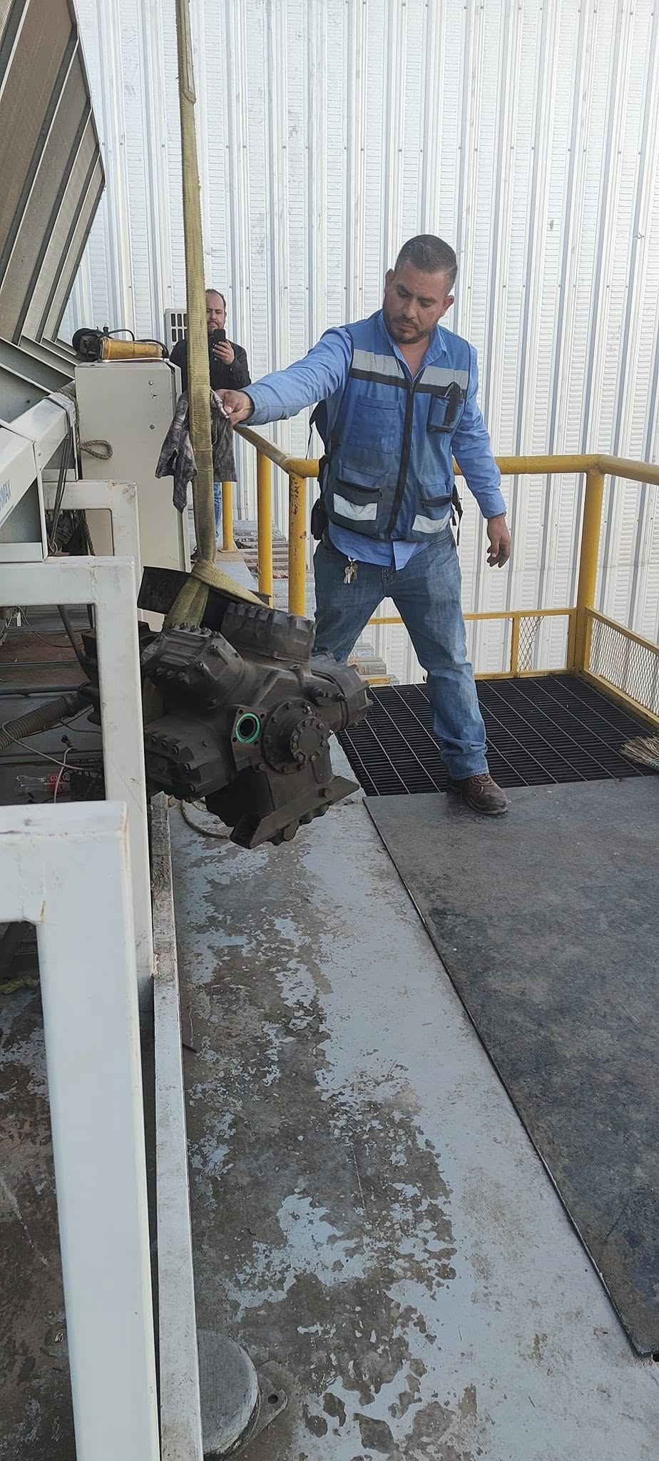 Técnico guiando un compresor en plataforma industrial