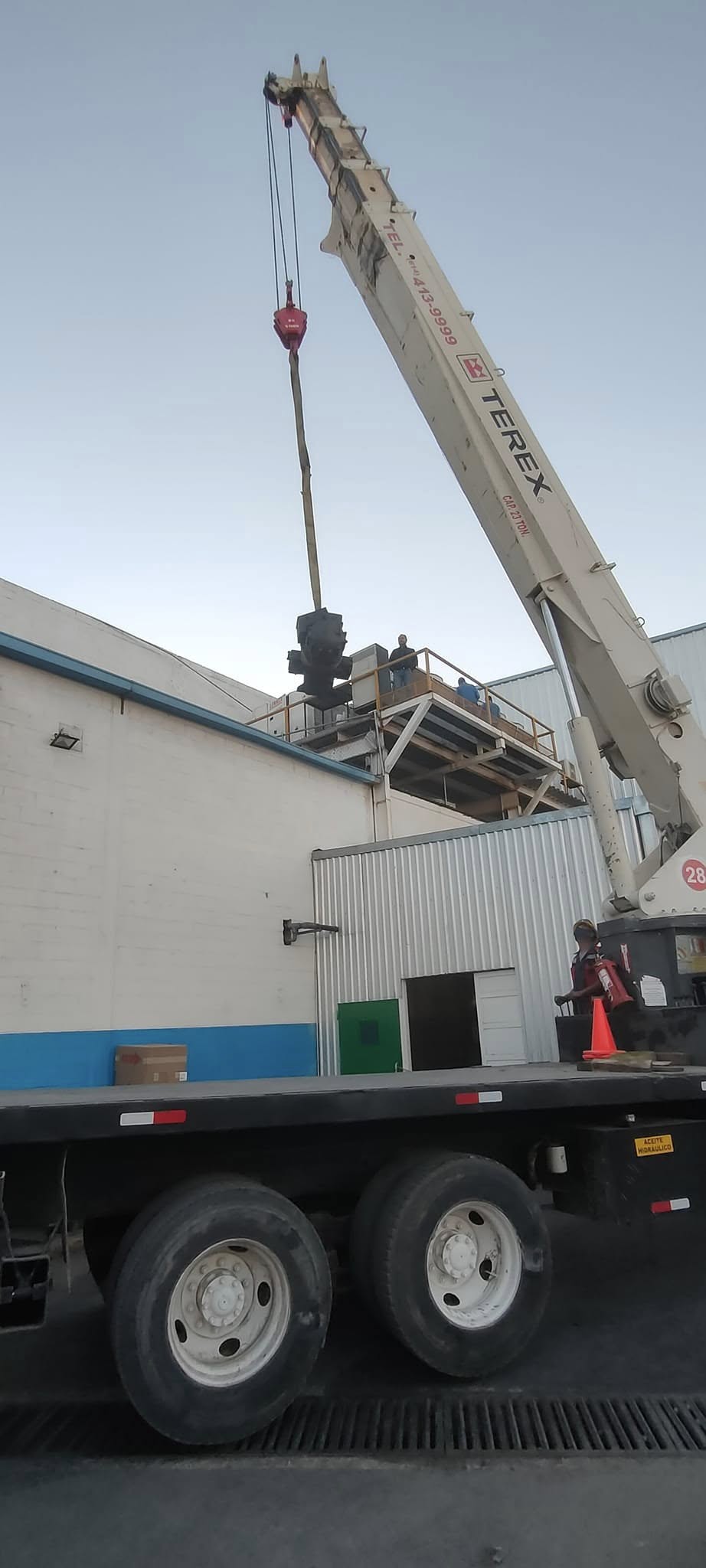 Maniobra con grúa para subir un compresor a planta industrial